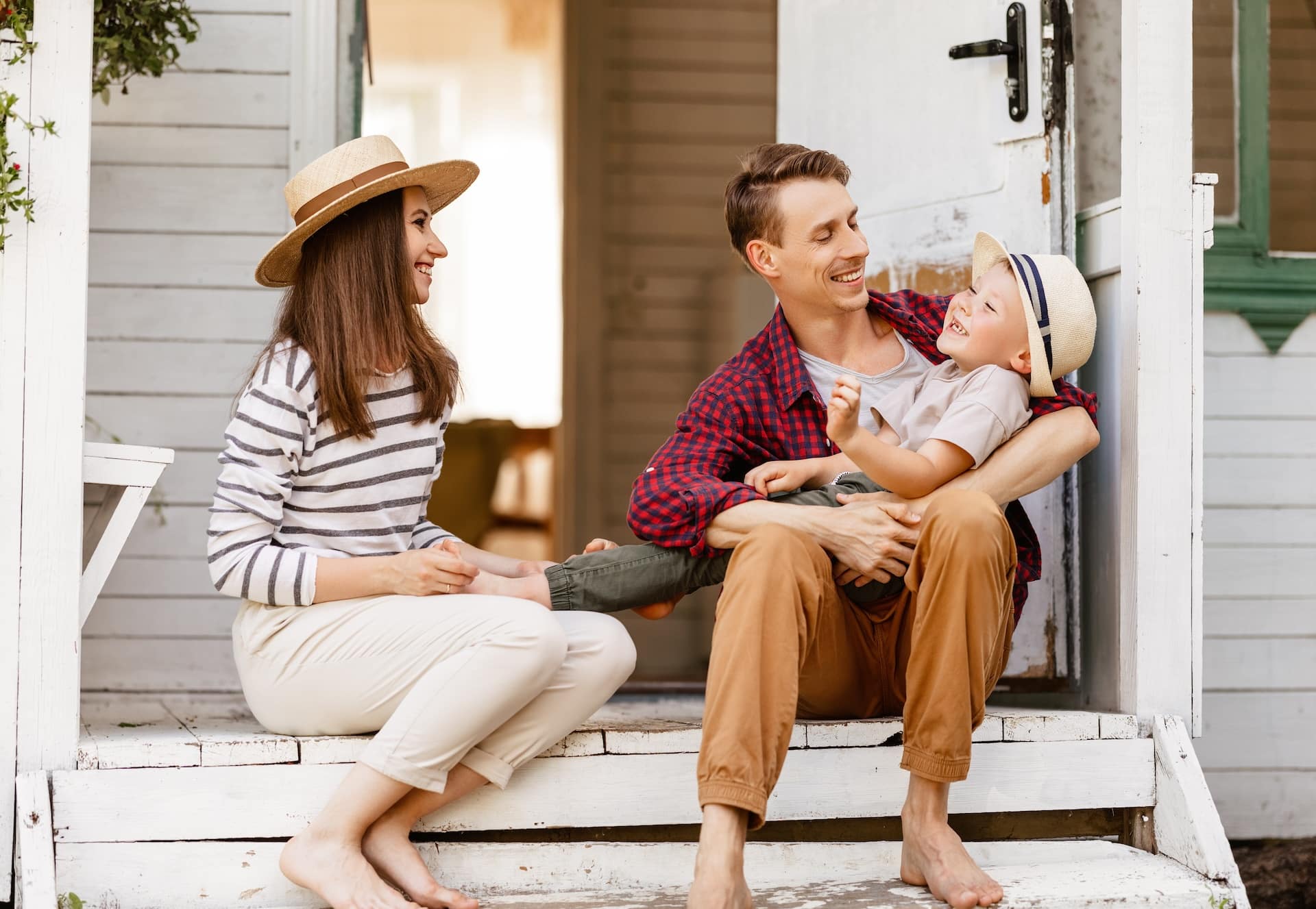 cheerful family is having a rest and having fun on the porch of a country house