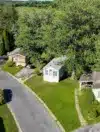 Aerial view of a tree-lined manufactured home street in Pennsylvania with green lawns and single-wide units