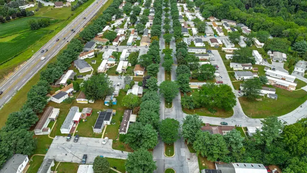 Wide aerial view of a large Pennsylvania manufactured home park next to highway and green farmland